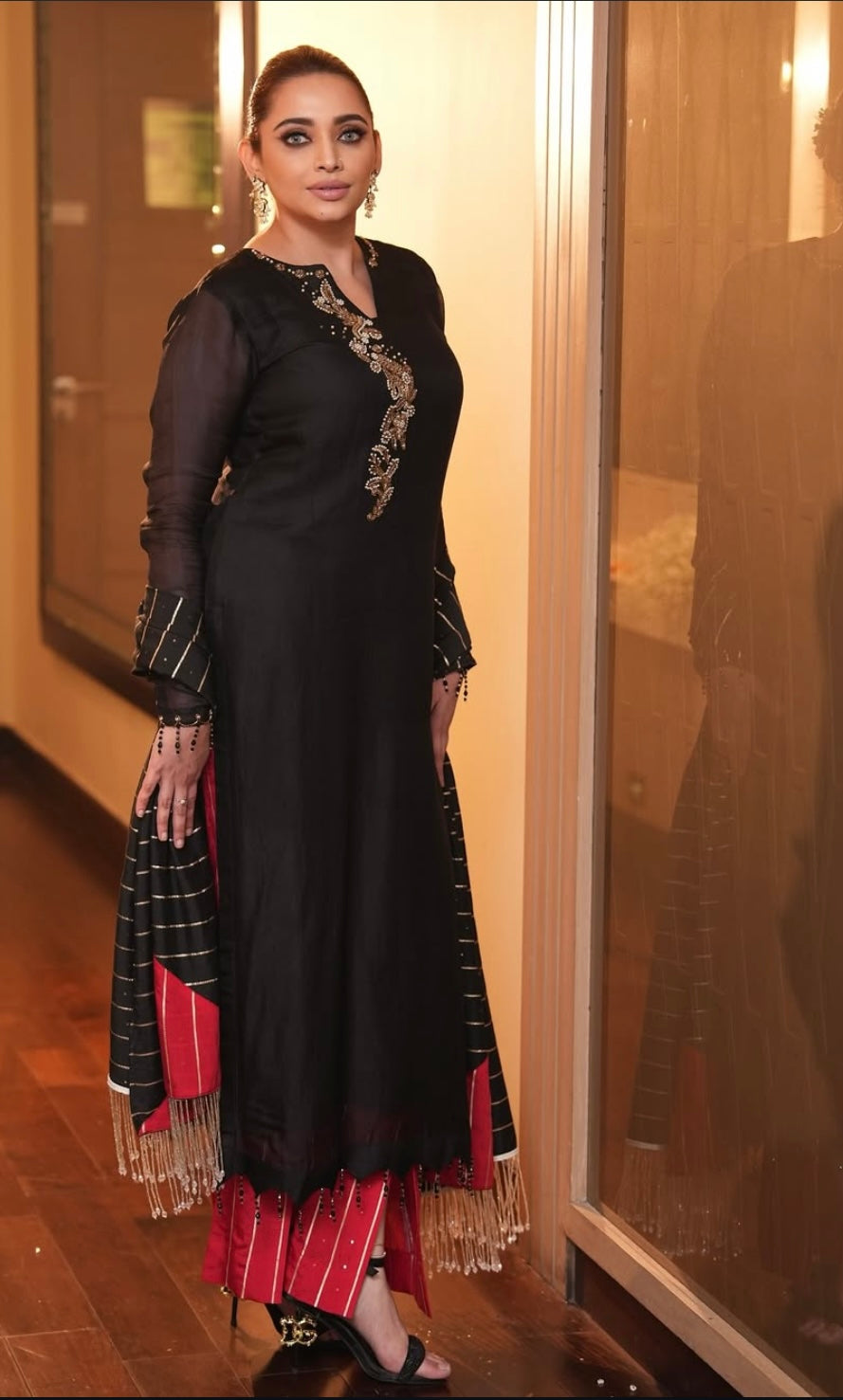Sleek black dress paired with striking red cut pants
