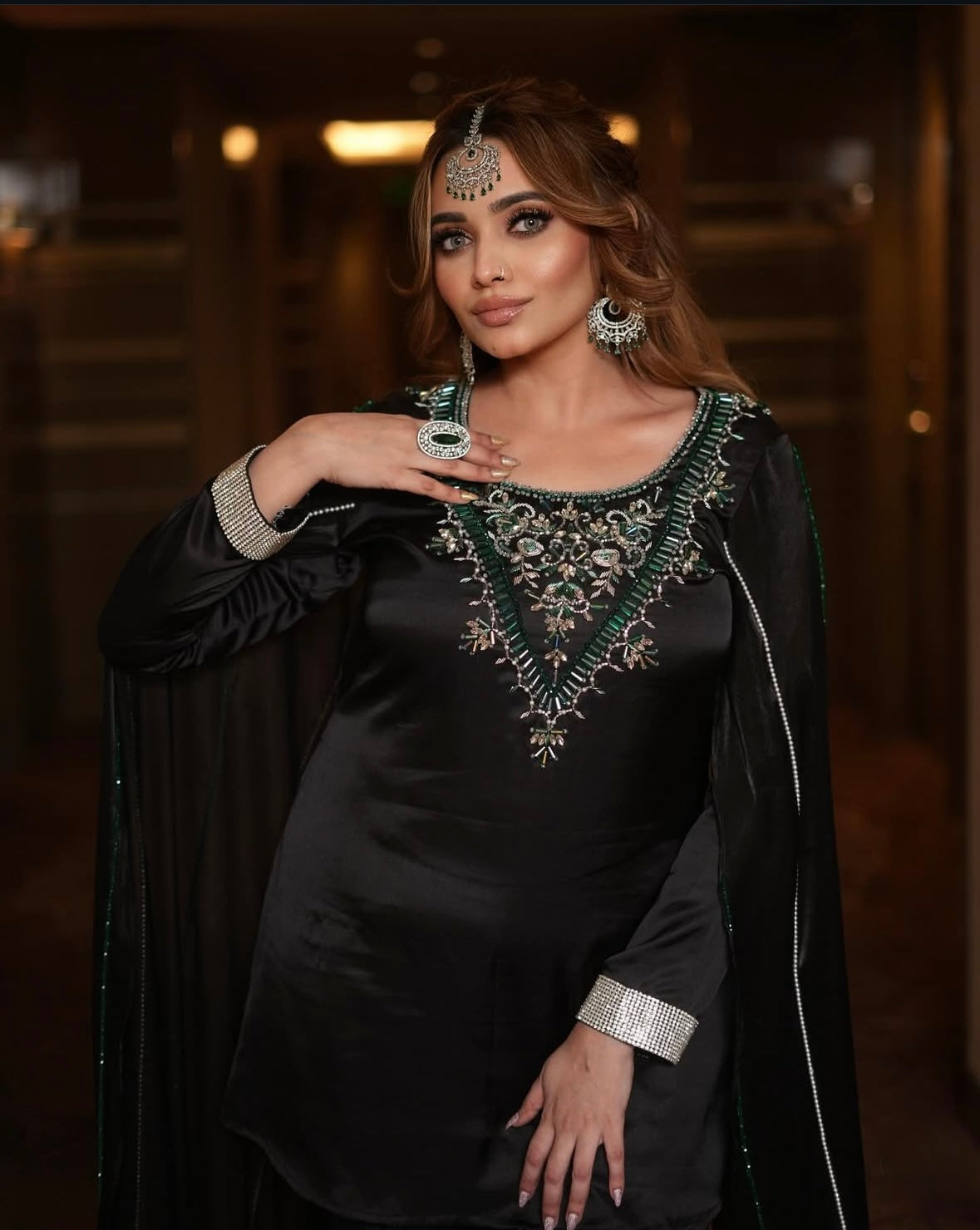 Dress features long sleeves and intricate green embroidery