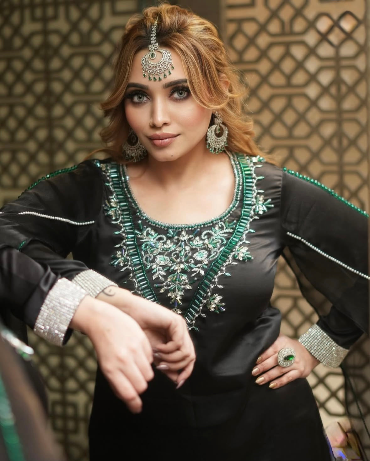Dress features long sleeves and intricate green embroidery