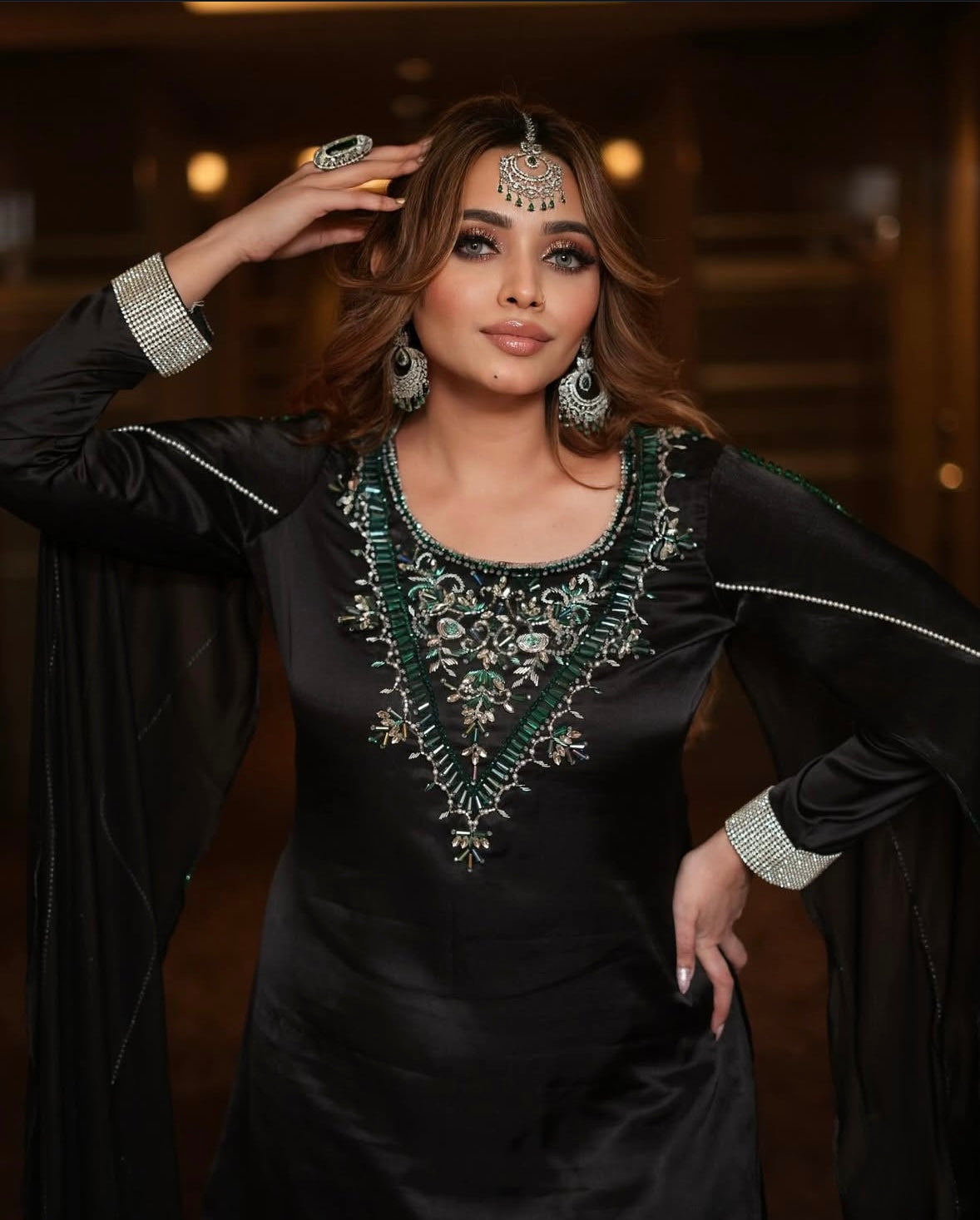 Dress features long sleeves and intricate green embroidery